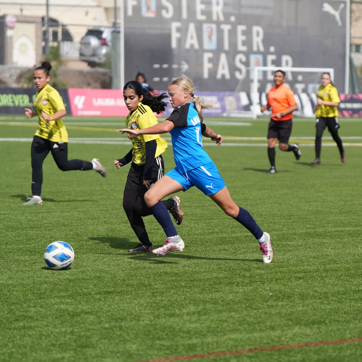A girls' match in progress on the pitch.