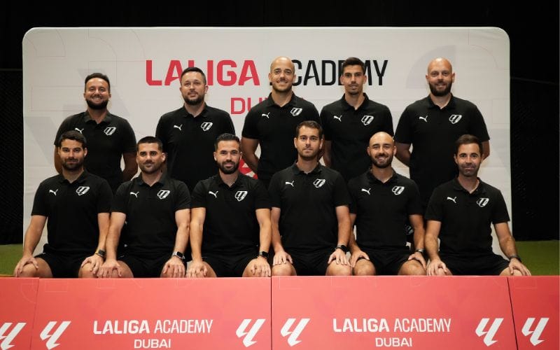 Academy coaching staff lined up on the pitch.